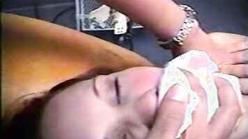 Hot MILF sucking cock in an XXX rape video laying flat on the bed.